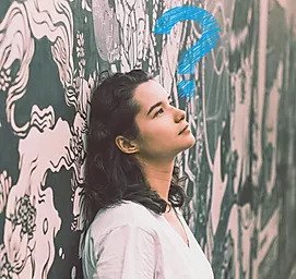 Girl wearing white dress standing in the wall with a blue question mark